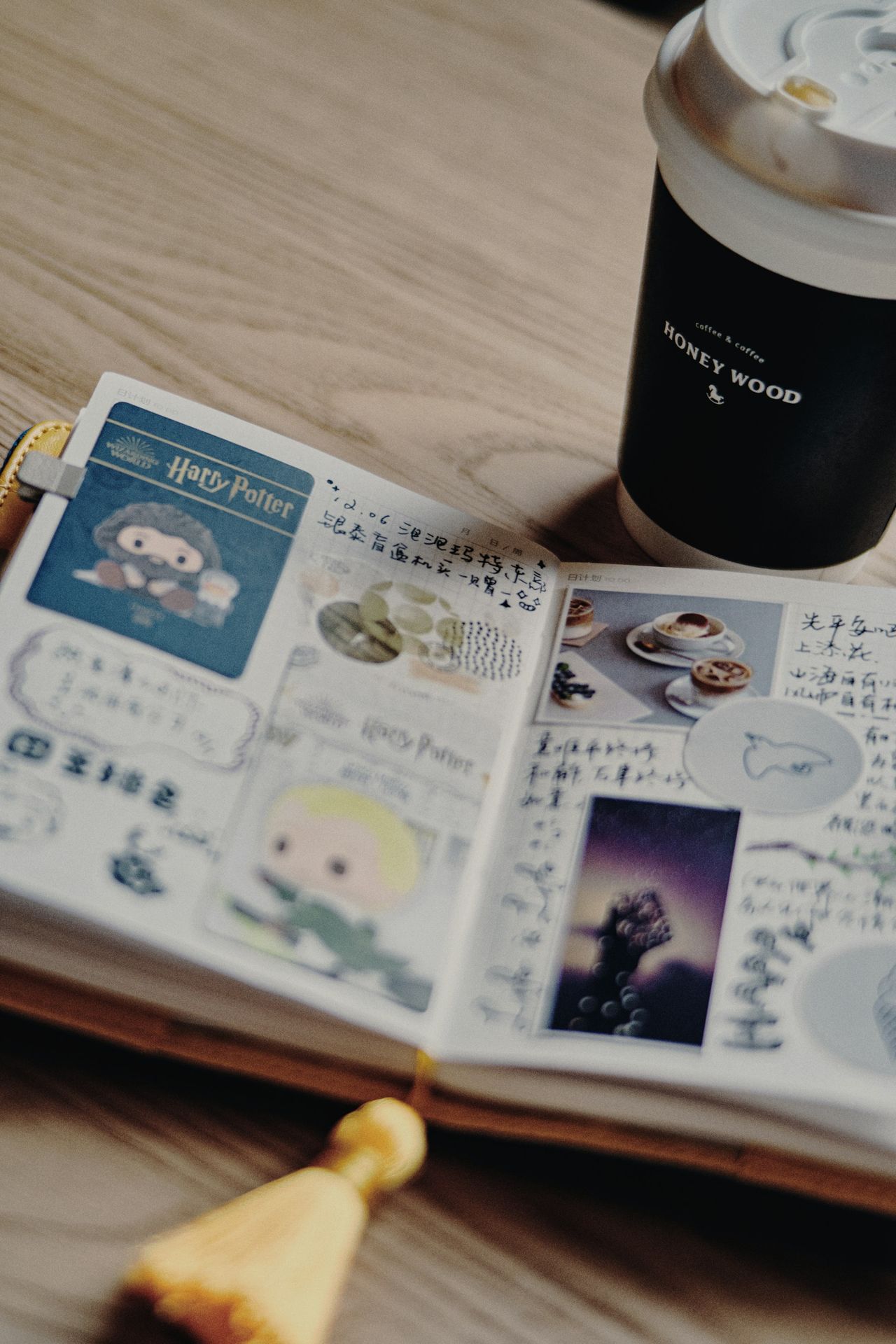 an open book sitting on top of a wooden table next to a cup of coffee